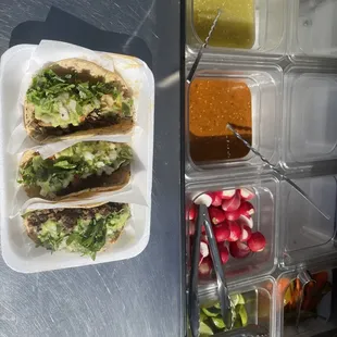 a tray of tacos and salads