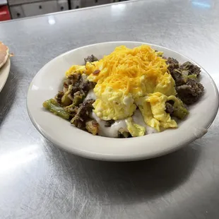 Breakfast bowl sausage gravy, eggs with green peppers, onions, home fries, your choice of meat and topped with cheddar cheese $10.99