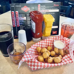 a tray of fried potatoes and a glass of soda