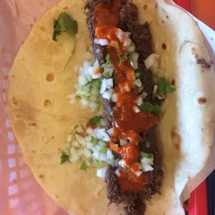 a taco with meat and onions