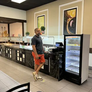 a man standing in front of a refridgerator