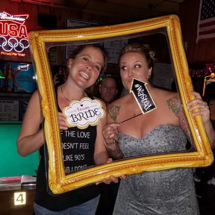 two women holding up a picture frame