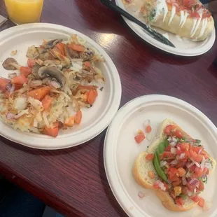Loaded hash brown, avocado toast and mimosa . Veggie breakfast burrito in back.