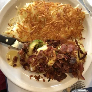 Avocado bacon eggs Benedict with hash browns.