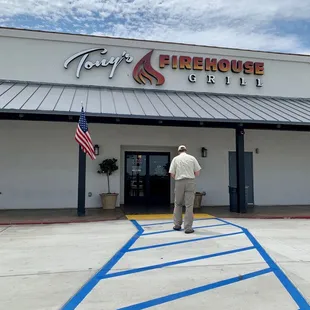 a man standing in front of the firehouse grill