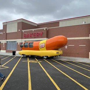 a large hot dog in a parking lot