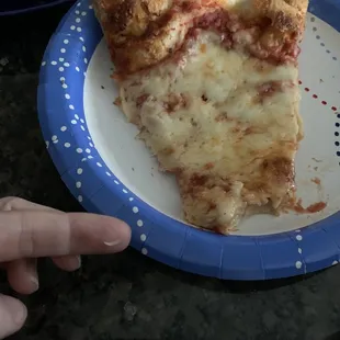 a slice of pizza on a paper plate