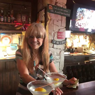 a woman sitting at a bar with a martini