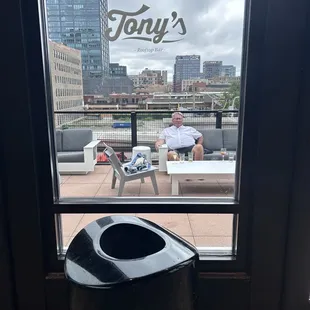 a man sitting in a chair looking out the window