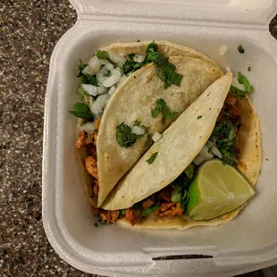 two tacos in a styrofoam container