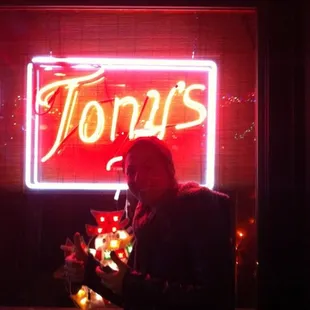 a man in front of a neon sign