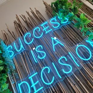 a neon sign that says success is a decision