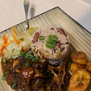 Oxtails, steamed Jamaican Cabbage, rice &amp; peas, and fried plantains.