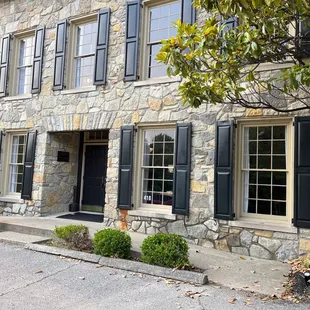 a stone building with black shutters