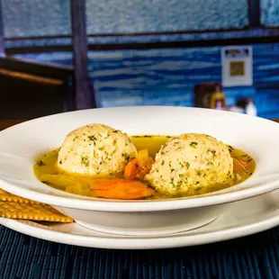 a bowl of soup with dumplings and carrots