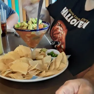 a plate of nachos and a drink