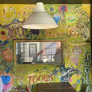 a table and chairs in front of a mural
