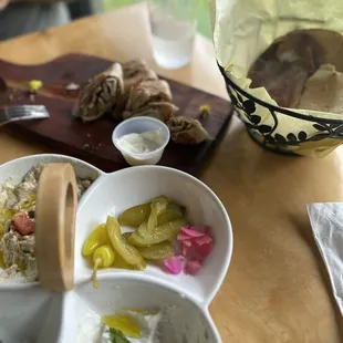 a wooden table with bowls of food and utensils
