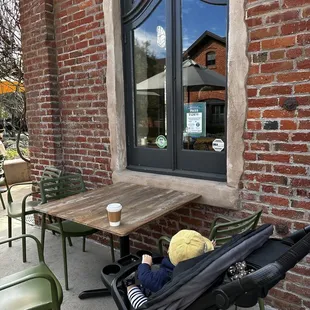 a baby in a stroller outside a cafe