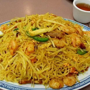 a plate of noodles with shrimp and vegetables