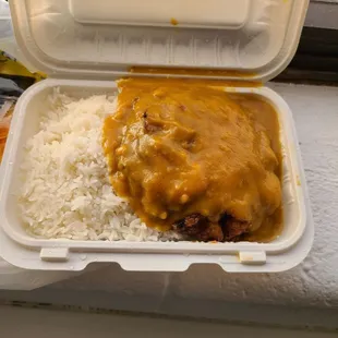 a takeout container with rice and curry