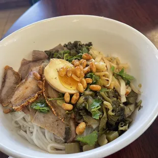 a bowl of noodles with meat and vegetables