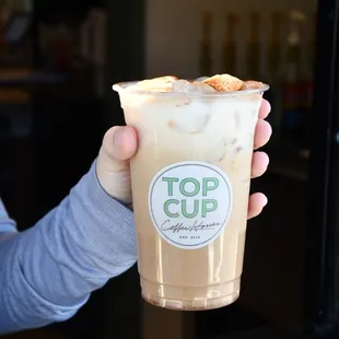 a hand holding a cup of iced coffee