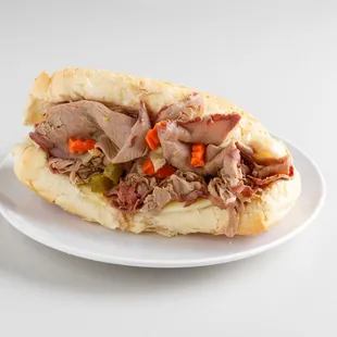 a meat and vegetable sandwich on a white plate