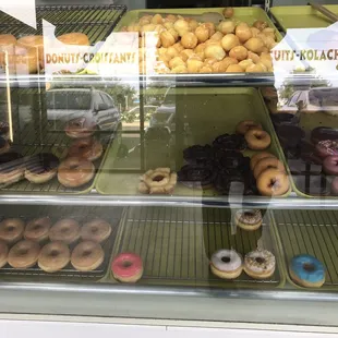 a variety of doughnuts in a display case