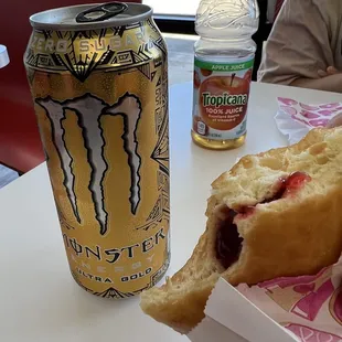 a half eaten donut and a can of energy drink