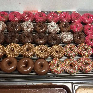 a variety of donuts on a cooling rack