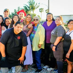 The chef posing with the graduate and his family