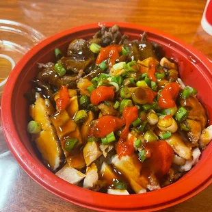 a red bowl of food on a wooden table