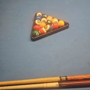 a pool table with pool balls and cues