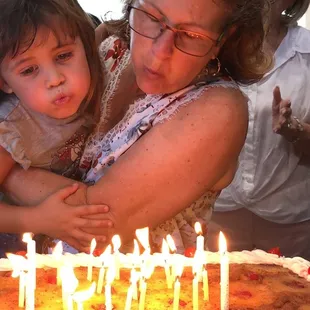 Here's my mom &amp; cousin blowing out the birthday candles!! We had 55 guests &amp; it fed everyone!!
