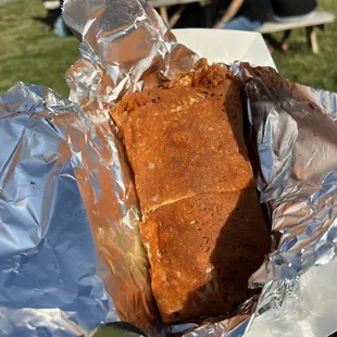 a piece of food wrapped in aluminum foil