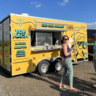 a woman standing in front of a food truck