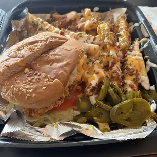 Shrimp sandwich on bun with loaded fries.
