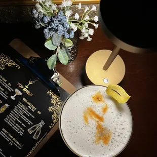 a glass of beer and a menu on a table