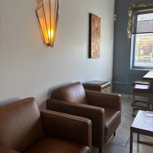 two brown leather chairs and a table