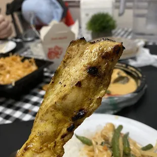 a chicken skewer with rice and vegetables