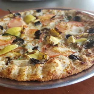 a pizza with olives and tomatoes