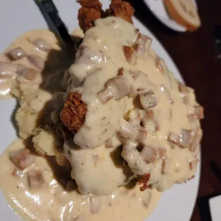 Tope La country fried steak topped with an andouille sauce on top of mashed potatoes