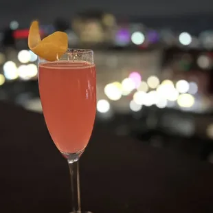 a glass of wine with a lemon wedge on the rim