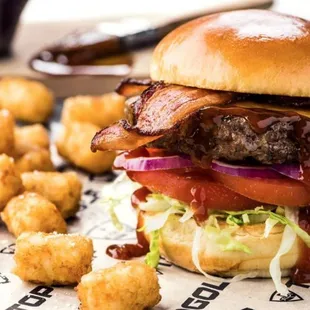 a burger and tater tots on a plate