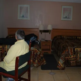 Room with two beds-  a desk, and a separate alcove with sink, fridge, microwave &amp; coffee pot