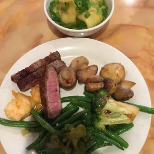 Lots of fresh vegetables and steak