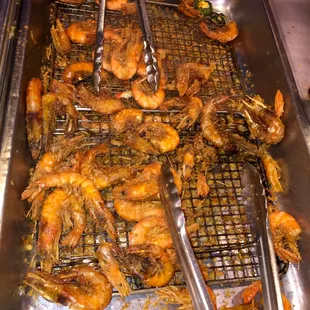 shrimp on a grill with tongs