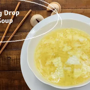 a bowl of egg drop soup with chopsticks