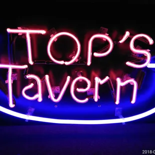 a neon sign that reads top's tavern
